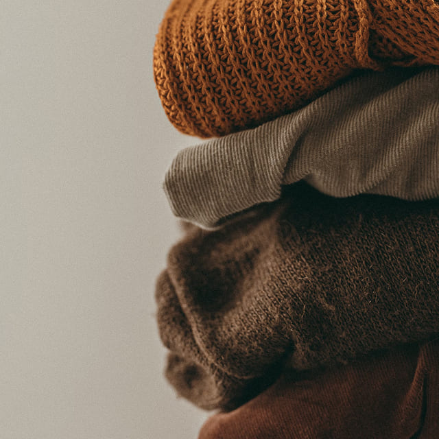 Stacked winter knits in warm neutral tones