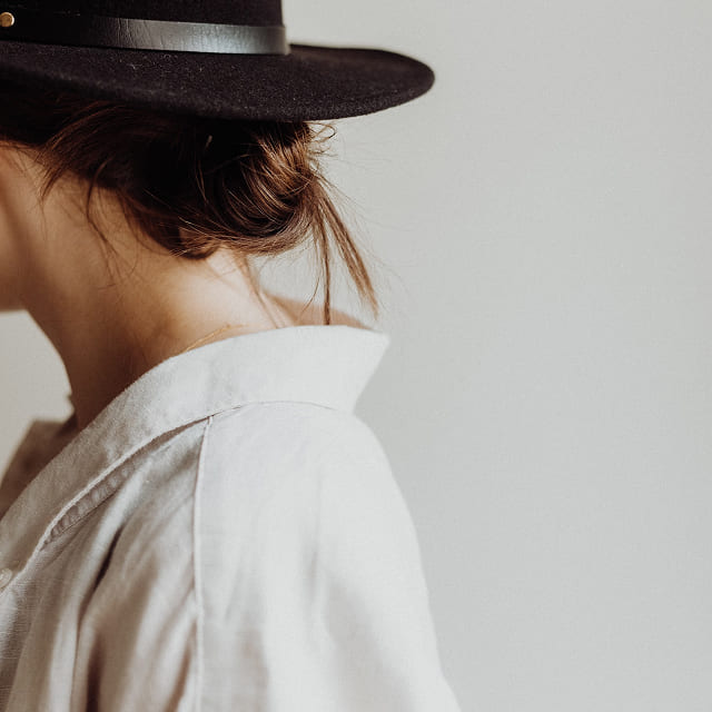 Woman in a crisp white shirt and dark hat